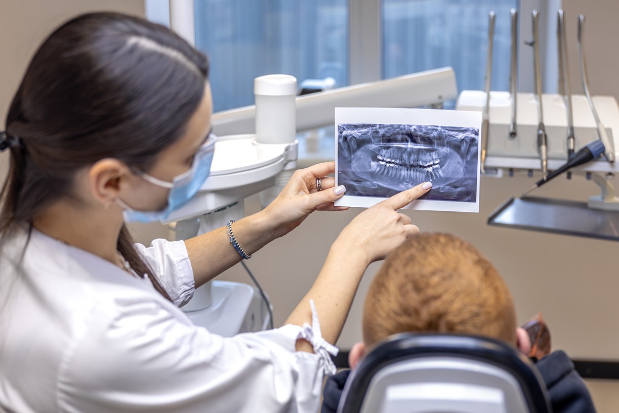 Dentist explaining dental X-ray to a child patient.